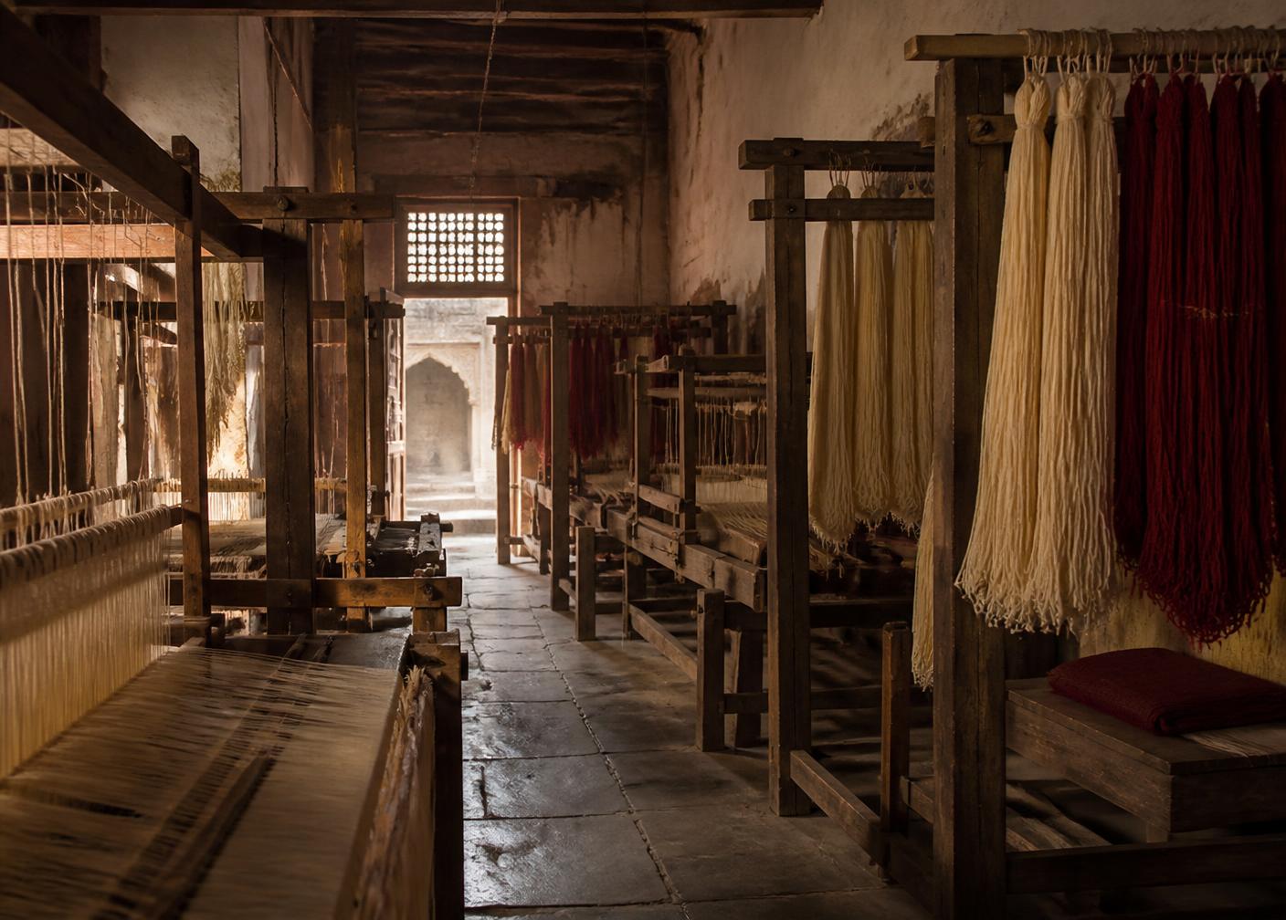 Wooden looms and hanging dyed thread in a Kota workshop